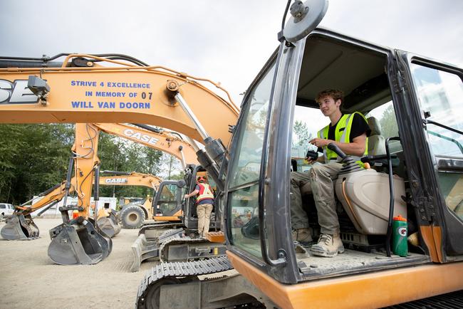 Young man sitting in the cab of an excavator