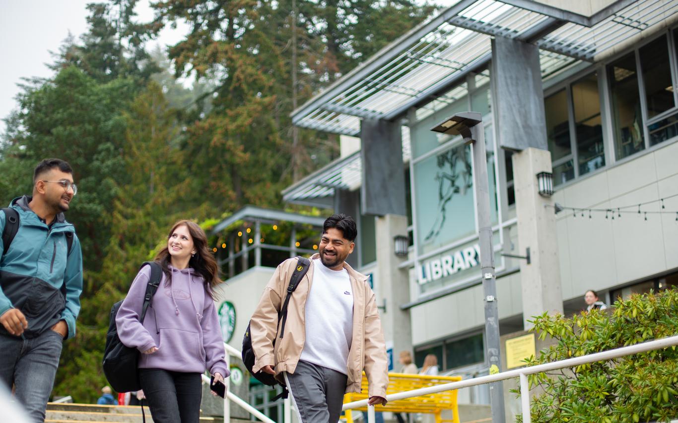 Happy students walking by the VIU library